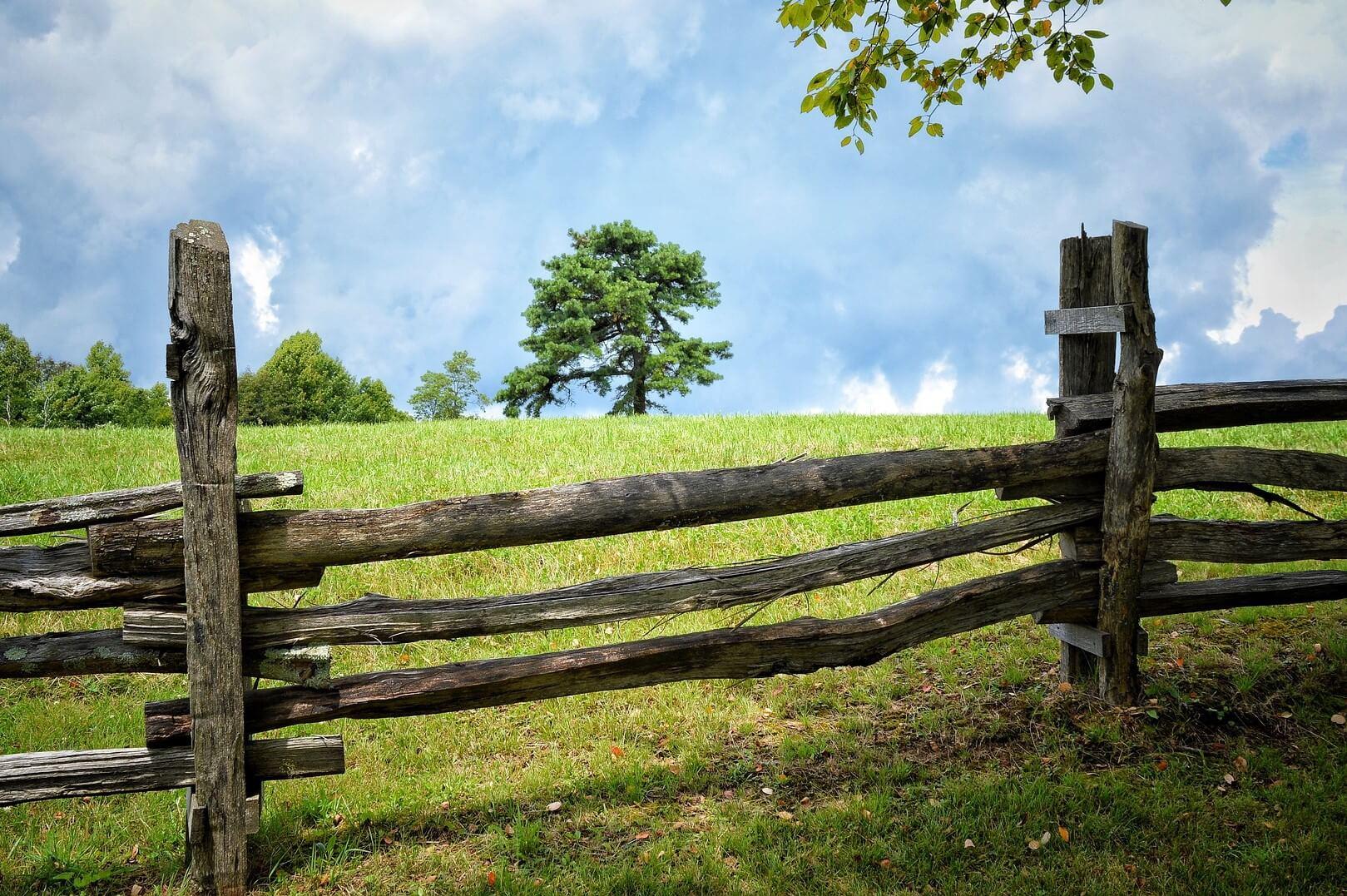 Split rail fence in front of a grassy field