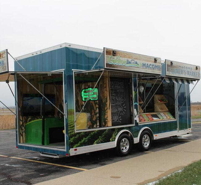 Macomb County exhibit trailer with panels pulled up to show displays inside