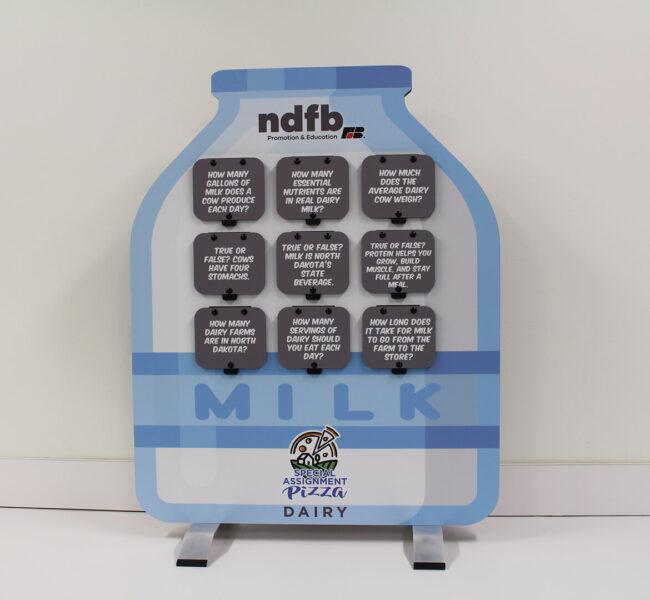 Tabletop milk bottle display with dairy facts