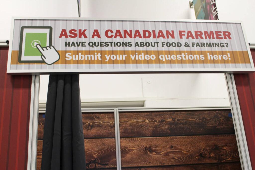 Sign reading, "Ask a Canadian Farmer. Have questions about food & farming? Submit your video questions here!"