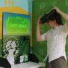 A woman demonstrates how to put on the VR headset