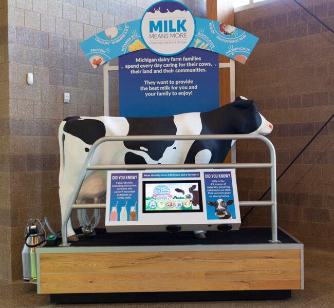 Milking cow display with cow sculpture and video monitor.