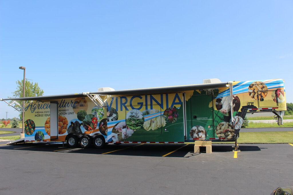VSU agricultural exhibit trailer with sections slid out and sunshades put up.